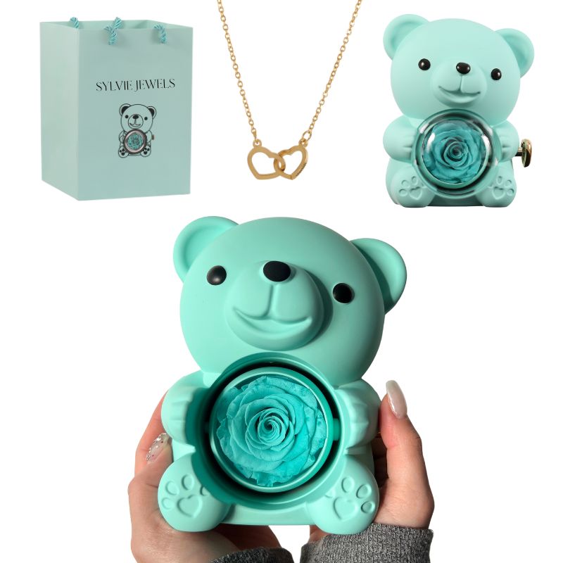 Offrez un cadeau unique et plein d’émotion avec l’Ours Rose Éternelle avec Collier Gravé. Cet adorable ours renferme une rose éternelle préservée et un collier à deux cœurs, chacun pouvant être gravé avec un prénom, une date ou un message unique. Un symbole d’amour éternel idéal pour la Saint-Valentin, la Fête des Mères, un anniversaire ou toute occasion spéciale. Présenté dans un sac cadeau Sylvie Jewels, ce cadeau personnalisé saura toucher le cœur de votre proche et créer un souvenir inoubliable.
