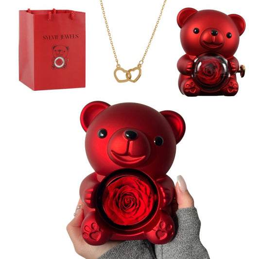 Offrez un cadeau unique et plein d’émotion avec l’Ours Rose Éternelle avec Collier Gravé. Cet adorable ours renferme une rose éternelle préservée et un collier à deux cœurs, chacun pouvant être gravé avec un prénom, une date ou un message unique. Un symbole d’amour éternel idéal pour la Saint-Valentin, la Fête des Mères, un anniversaire ou toute occasion spéciale. Présenté dans un sac cadeau Sylvie Jewels, ce cadeau personnalisé saura toucher le cœur de votre proche et créer un souvenir inoubliable.